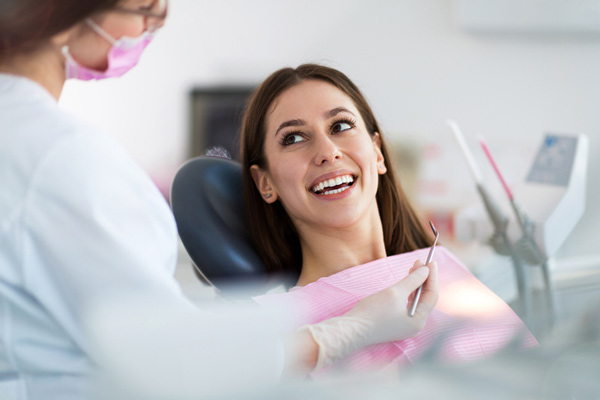 Woman leaning back in dental chair looking up at dentist at Detailed Dental Care in Massapequa, NY.